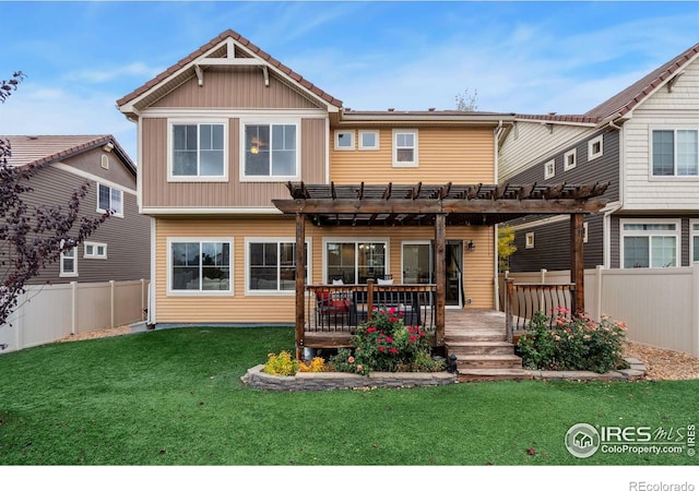 back of property featuring a wooden deck, a pergola, and a yard