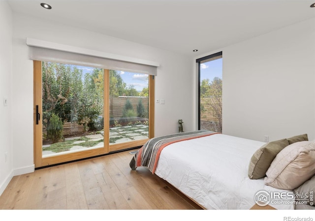 bedroom with access to exterior, wood-type flooring, and recessed lighting