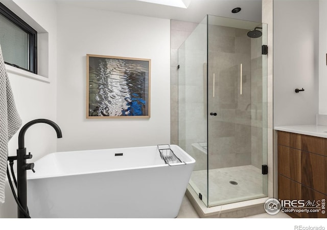 bathroom featuring a stall shower, a soaking tub, and vanity