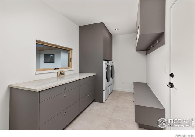 washroom featuring cabinets, washing machine and clothes dryer, and light tile patterned floors