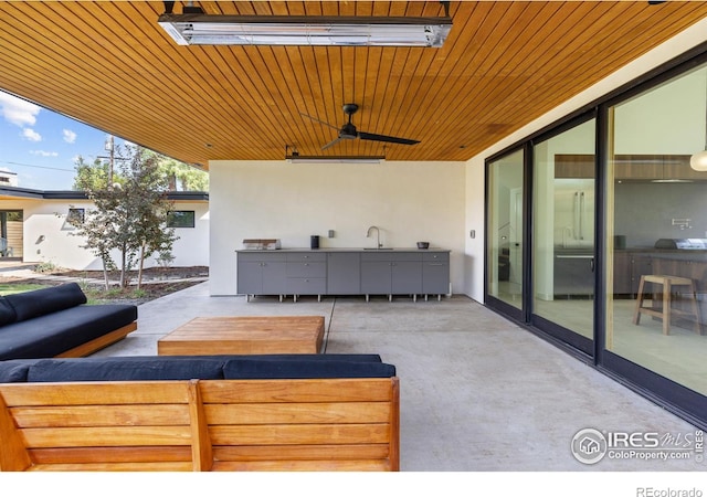 view of patio with a sink, outdoor lounge area, and a ceiling fan