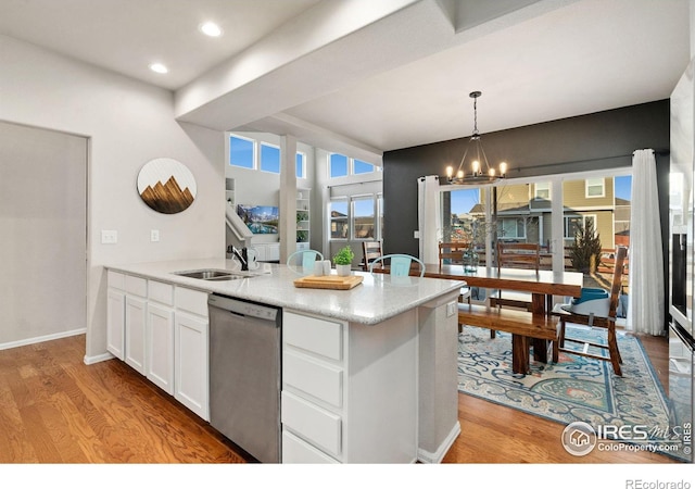 kitchen with sink, light hardwood / wood-style flooring, dishwasher, white cabinets, and decorative light fixtures