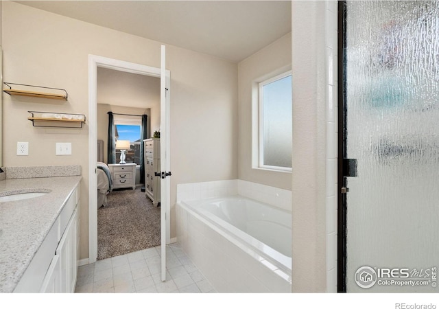 bathroom with vanity and tiled tub