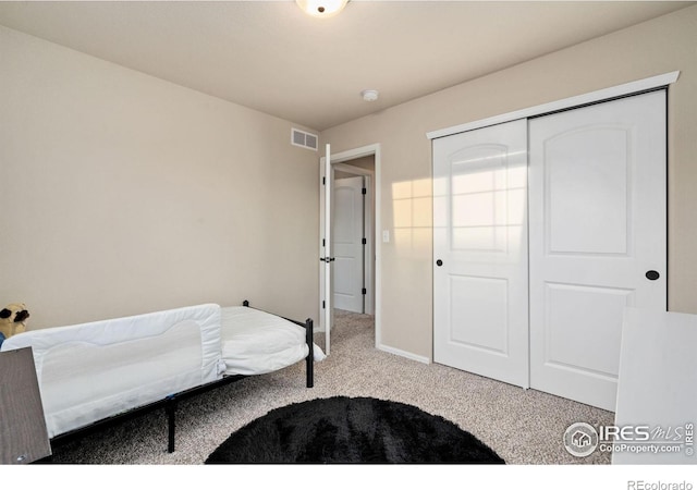 bedroom with light carpet and a closet