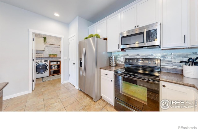 kitchen with washer / dryer, appliances with stainless steel finishes, white cabinets, and backsplash