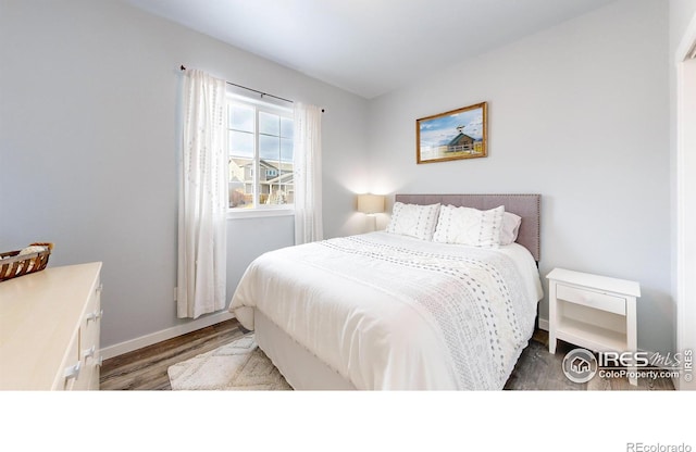 bedroom with dark hardwood / wood-style floors