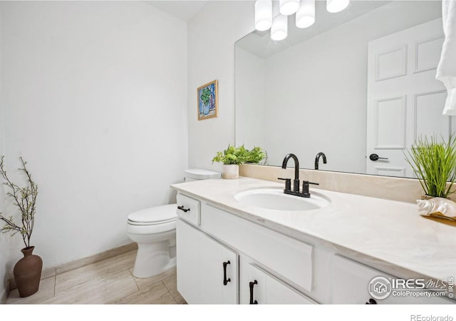 bathroom featuring vanity, wood-type flooring, and toilet