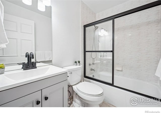 full bathroom featuring vanity, bath / shower combo with glass door, and toilet