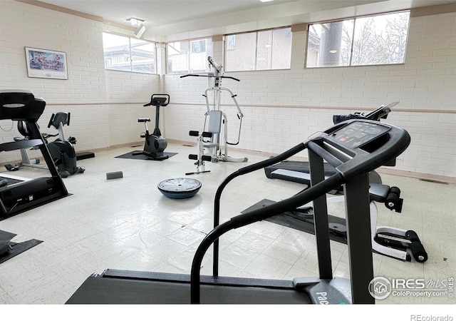 exercise room featuring brick wall