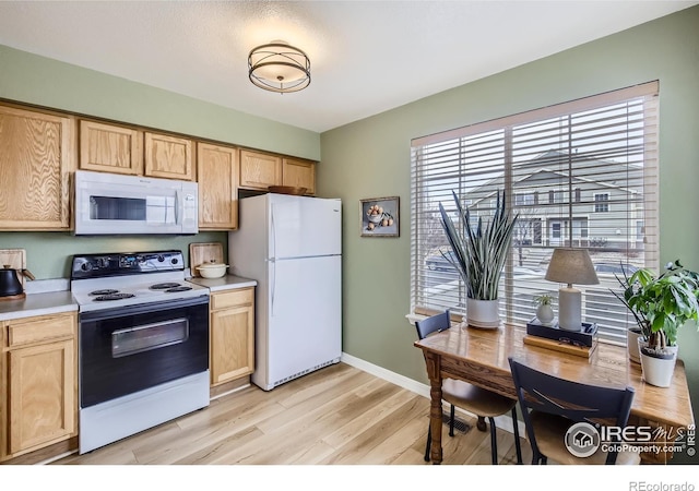 kitchen featuring white appliances and light brown cabinets