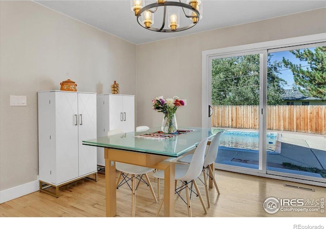 dining room featuring hardwood / wood-style flooring and an inviting chandelier