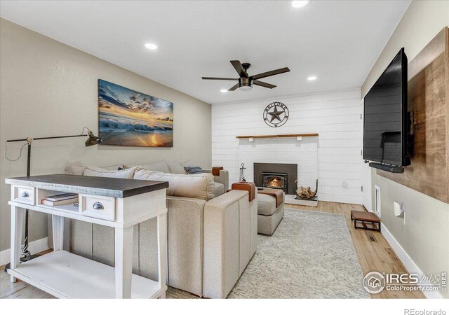 living room featuring ceiling fan and light hardwood / wood-style floors