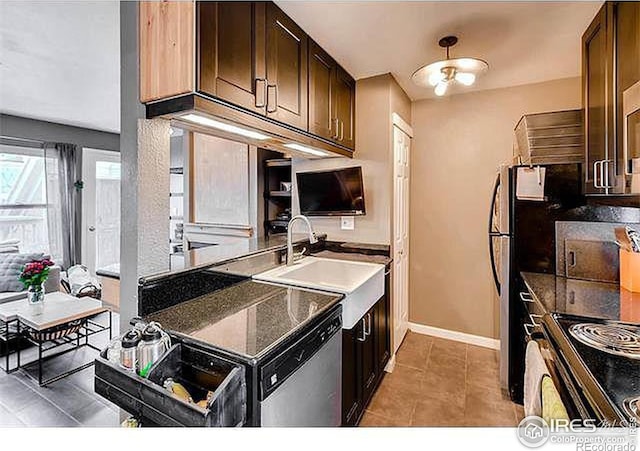 kitchen featuring baseboards, stainless steel dishwasher, light tile patterned floors, a sink, and dark brown cabinetry