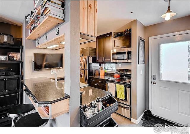 kitchen with stainless steel appliances, pendant lighting, and baseboards