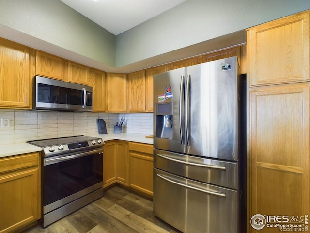 kitchen featuring backsplash, stainless steel appliances, and dark hardwood / wood-style floors