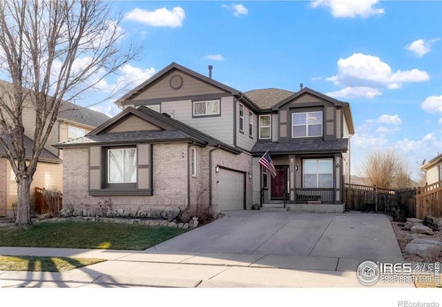 traditional-style home featuring brick siding, a shingled roof, concrete driveway, an attached garage, and fence