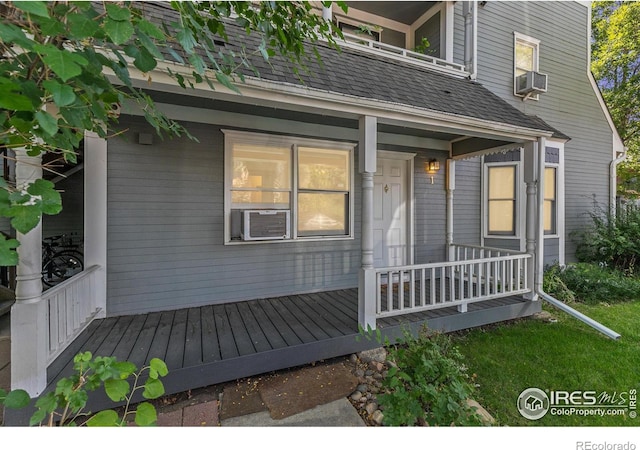 entrance to property with a porch and cooling unit