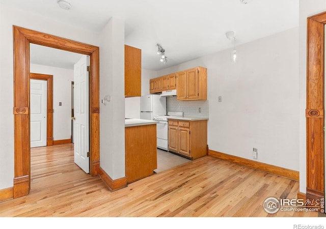 kitchen featuring backsplash, white appliances, and light hardwood / wood-style flooring