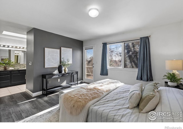 bedroom with hardwood / wood-style flooring and ensuite bathroom