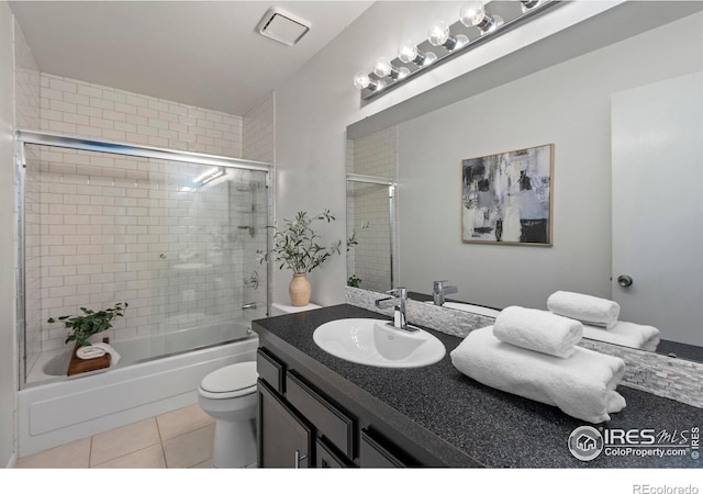 full bathroom with vanity, tile patterned floors, shower / bath combination with glass door, and toilet