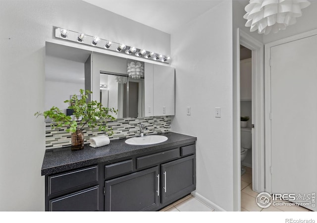 bathroom featuring tasteful backsplash, tile patterned floors, toilet, and vanity