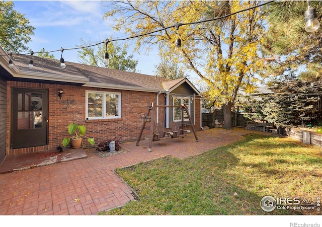 rear view of property featuring a yard and a patio