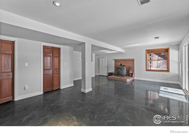 unfurnished living room featuring a textured ceiling and a wood stove