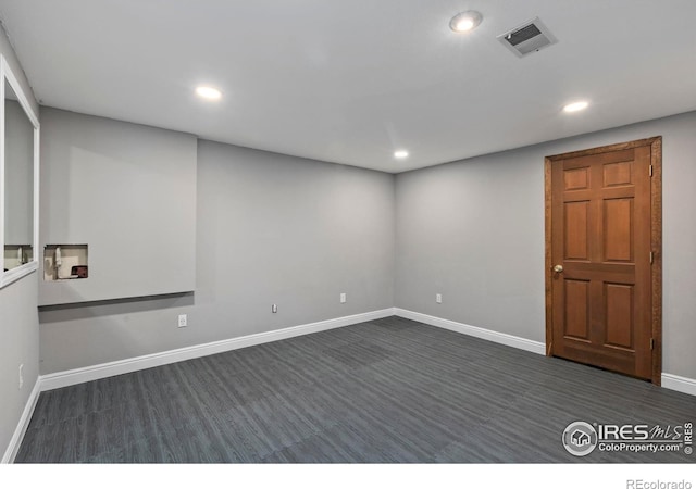 unfurnished room with dark wood-type flooring