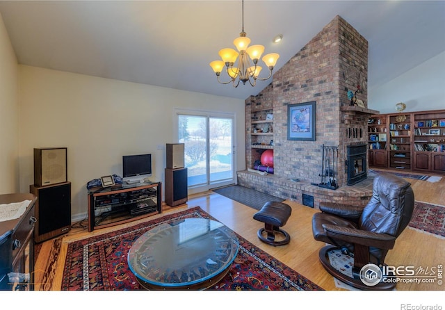 living room with hardwood / wood-style flooring, high vaulted ceiling, a chandelier, and built in shelves