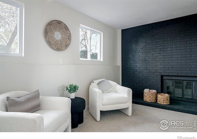 living area featuring light carpet and a fireplace