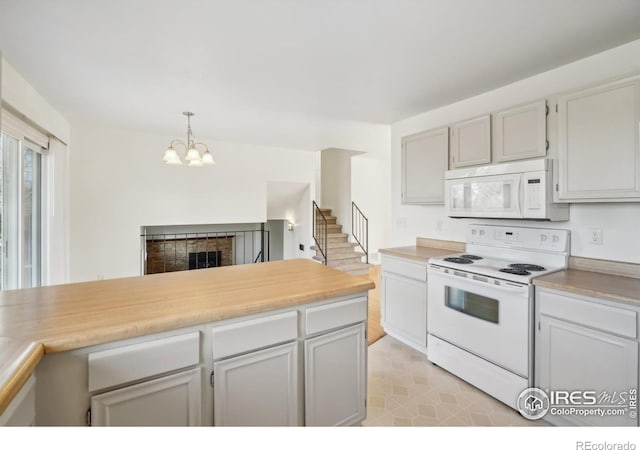 kitchen featuring pendant lighting, white appliances, a chandelier, and wood counters