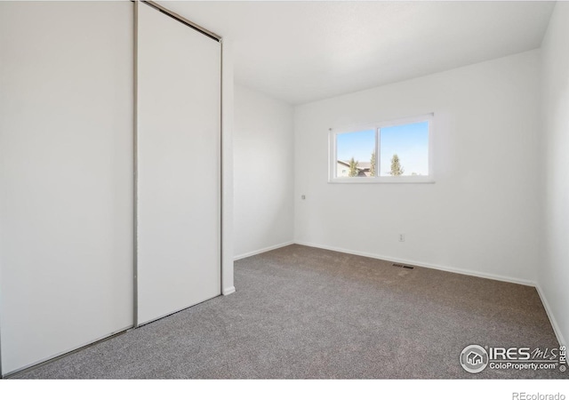 unfurnished bedroom with light carpet and a closet