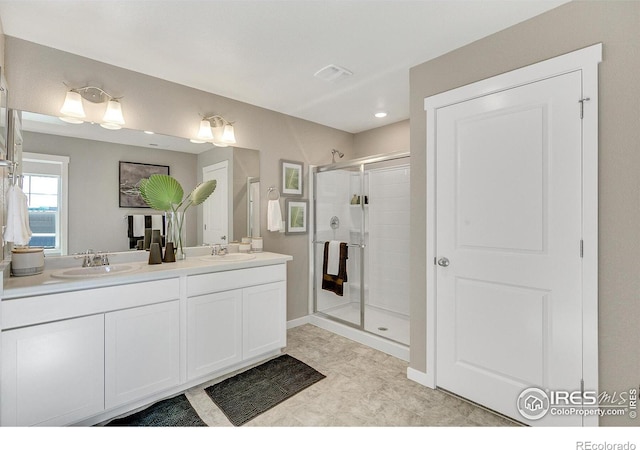 bathroom featuring a shower with door and vanity