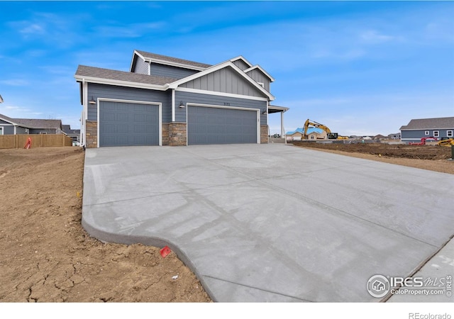 7172 Feather Reed Dr, Wellington, CO 80549 - view of front of home featuring stone siding, an attached garage, board and batten siding, and driveway