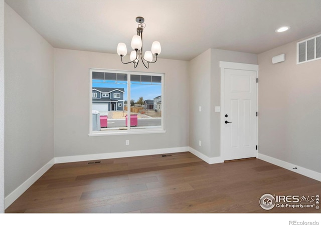 7172 Feather Reed Dr, Wellington, CO 80549 - unfurnished dining area with wood finished floors, baseboards, visible vents, recessed lighting, and an inviting chandelier