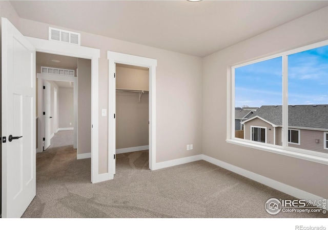7172 Feather Reed Dr, Wellington, CO 80549 - unfurnished bedroom with baseboards, visible vents, a spacious closet, and carpet flooring