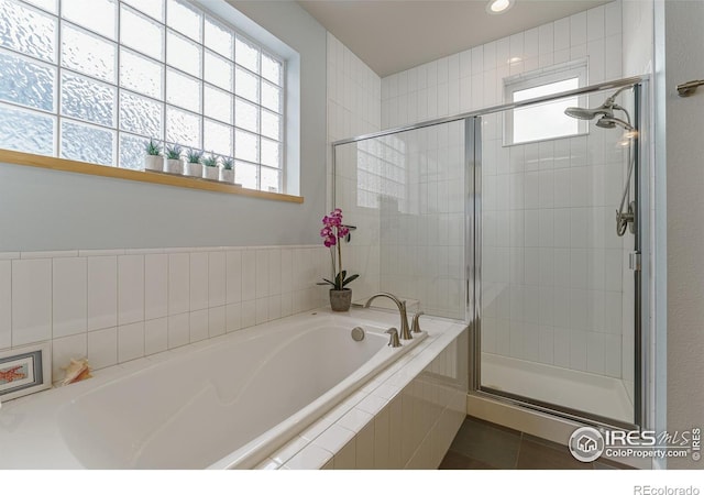 bathroom with independent shower and bath and tile patterned flooring