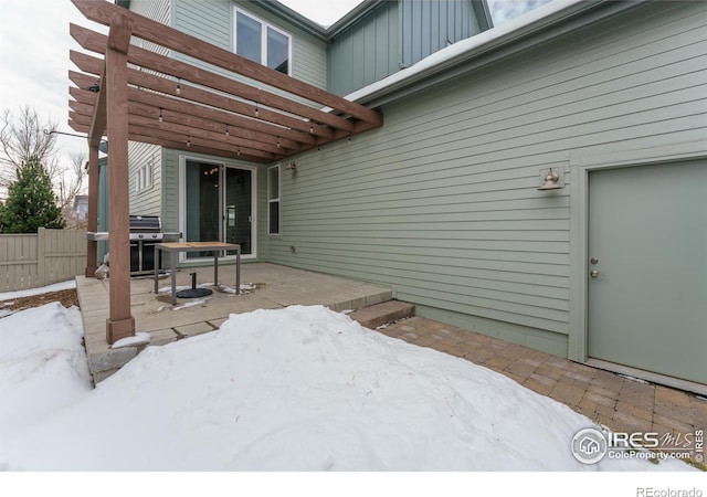 snow covered patio featuring a grill and a pergola