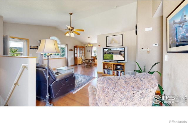 living room with hardwood / wood-style flooring, vaulted ceiling, and a wealth of natural light