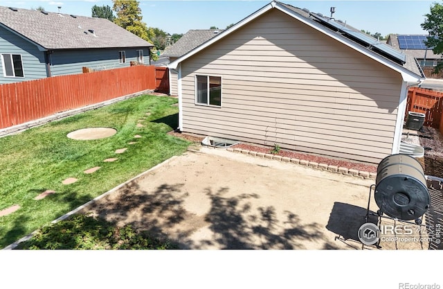 view of home's exterior with solar panels, a patio area, and a lawn