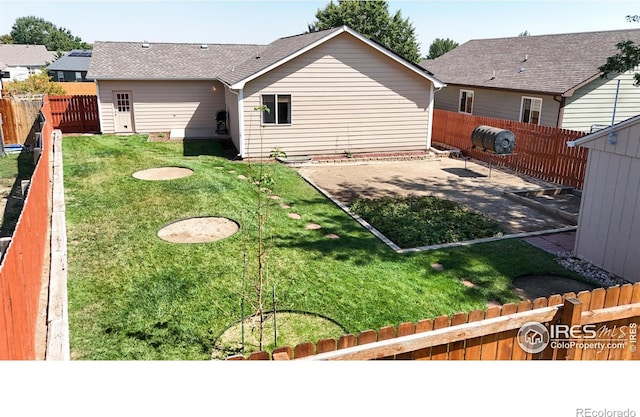 back of house with a yard and a patio