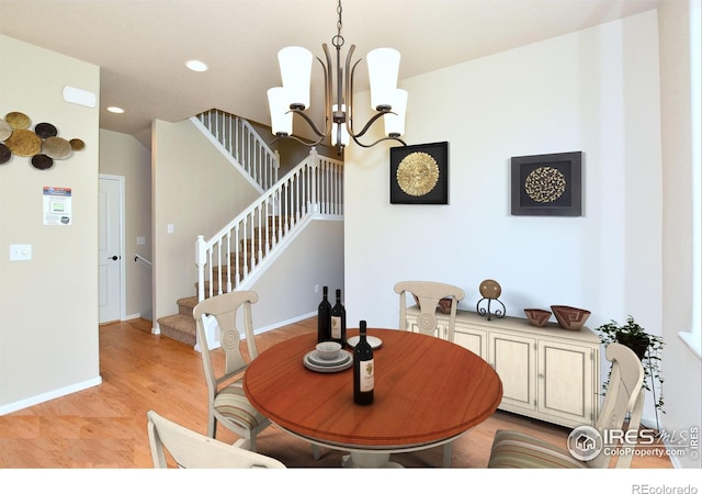 dining area with light hardwood / wood-style floors and a chandelier