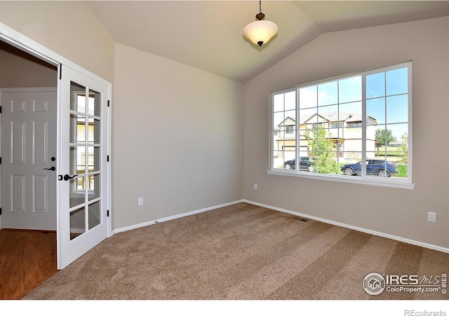 unfurnished room featuring lofted ceiling and carpet