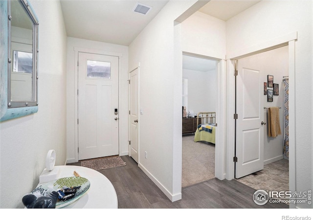 foyer entrance with electric panel, wood finished floors, visible vents, and baseboards