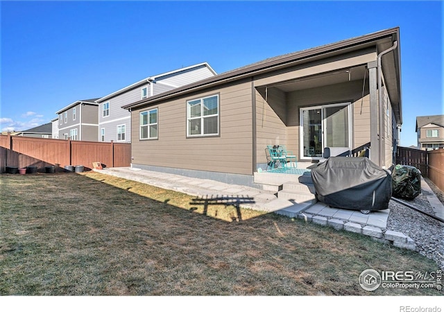 rear view of property with a patio area, a lawn, and a fenced backyard