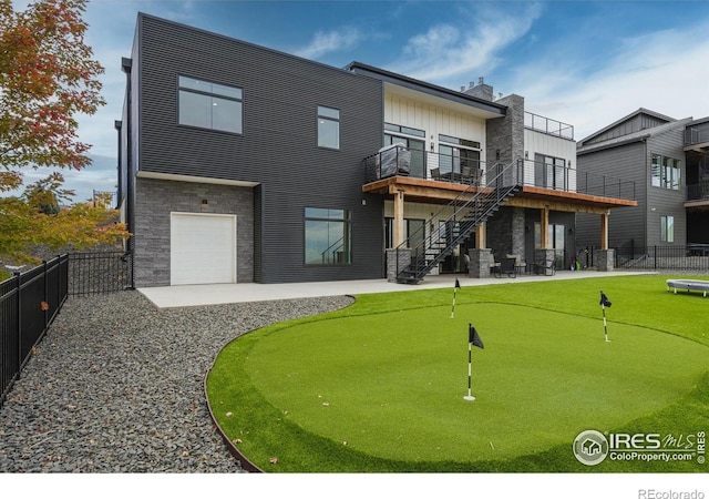 rear view of house with a garage, a patio, stairway, and fence