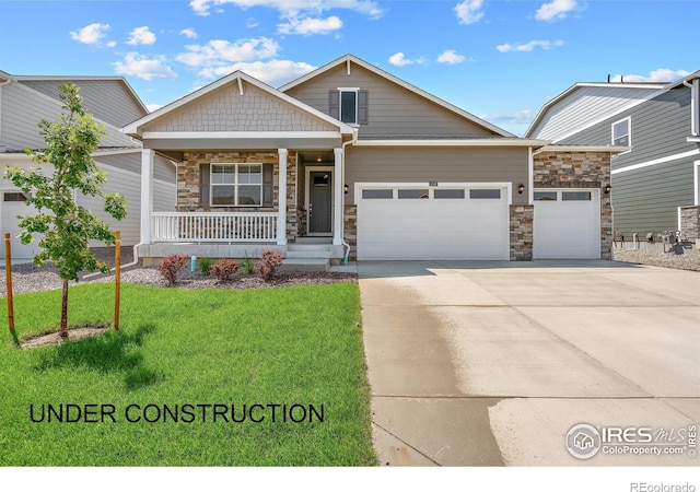 view of front of property with a porch, a garage, and a front lawn