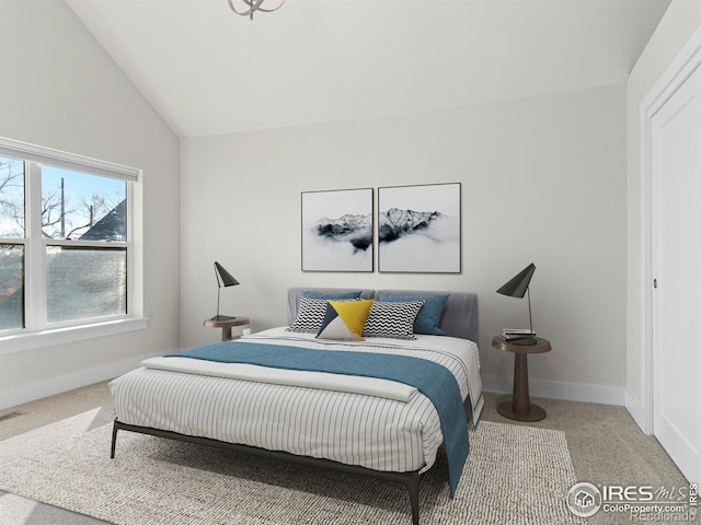 bedroom with vaulted ceiling and carpet floors