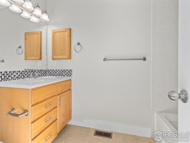 bathroom featuring vanity and tiled shower / bath