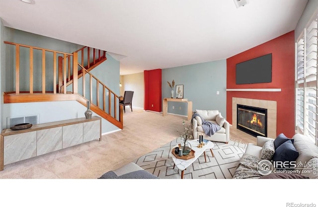 living room featuring light colored carpet and a tile fireplace